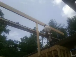 Carpenter setting a ridge beam over a new addition frame — Ice Dam Removal by Roofing Brothers in South Acworth