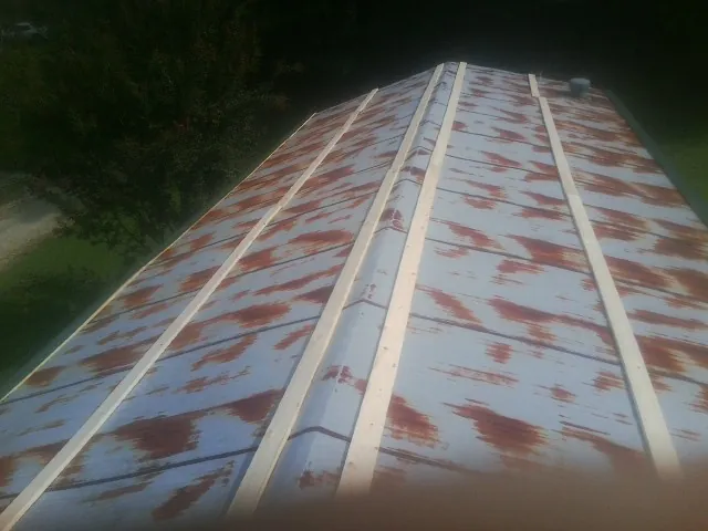 Rusted metal roof panels with new wood purlins before replacement — Storm Damage Roof Repair in South Acworth by Roofing Brothers