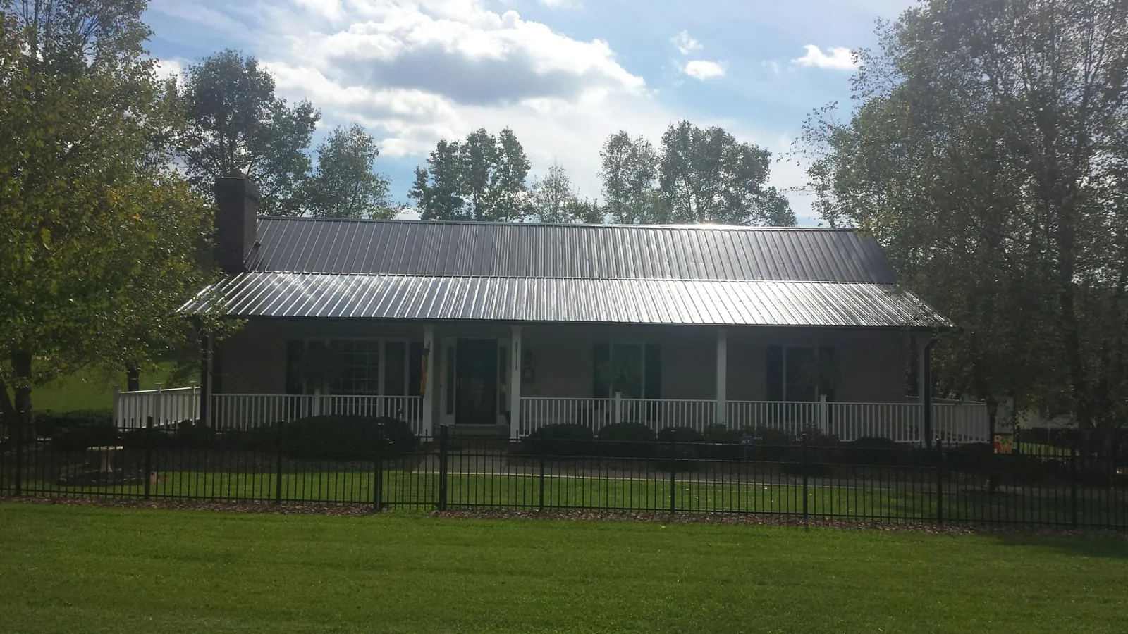 Gray metal roof on a brick ranch with a full width front porch — Gutter Guard Installation work by our crew in South Acworth