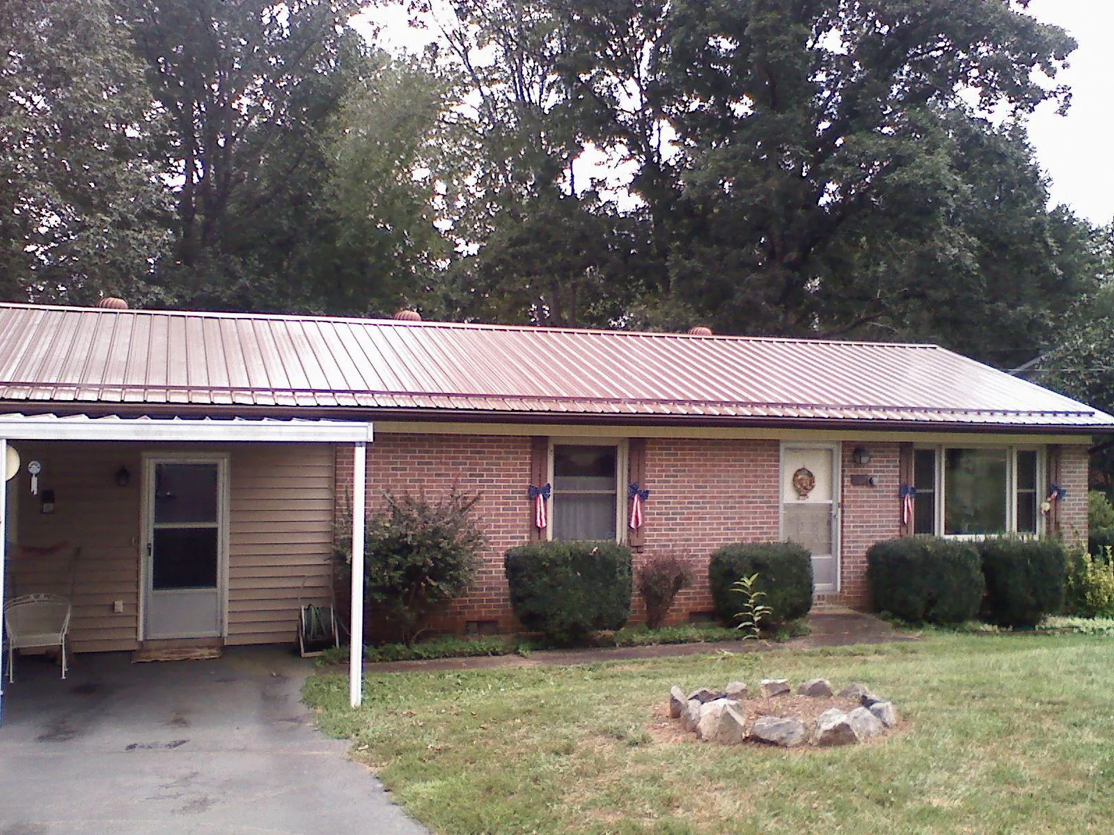 Bronze metal roof and carport on a brick ranch home — Roof Repair work by our crew in South Acworth